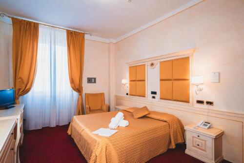 a hotel room with a bed and a television at Grand Hotel Milano in Chianciano Terme