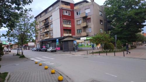 Une rue vide avec des oranges sur le côté d'un bâtiment dans l'établissement Apartman Rada, à Pirot
