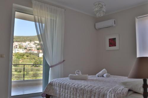 a bedroom with a bed and a large window at ARIA Luxury Apartments in Nafplio