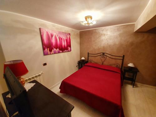 a bedroom with a red bed with a red blanket at Villa Antonella in Carlentini
