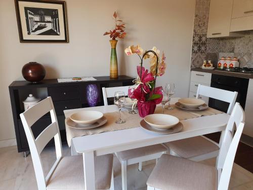 a white dining room table with chairs and flowers on it at Villa Antonella in Carlentini