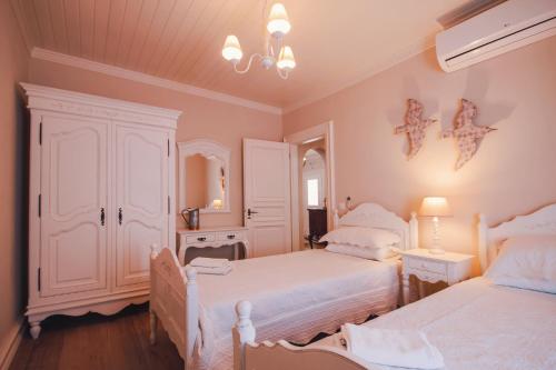 a bedroom with two twin beds and a mirror at The Durrell White House in Kalami