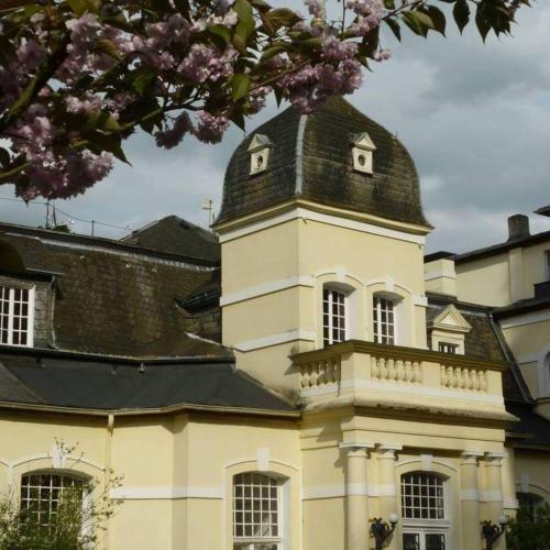 un edificio con una torre de reloj encima en Haus Annaberg en Bonn