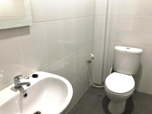 a bathroom with a white toilet and a sink at Wisma Grace in Ambon