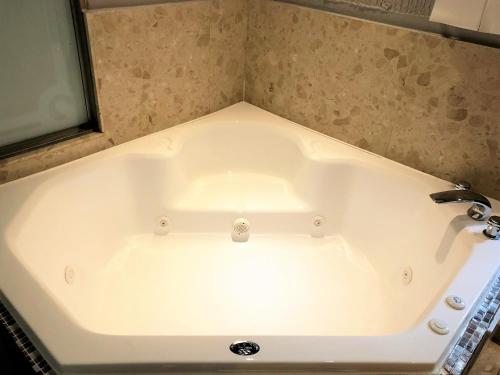 a white bath tub in a bathroom with a sink at Guest Motel-Zhubei in Zhubei