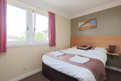 a bedroom with a bed and a window at Boreland Lodge Hotel in Inverkeithing