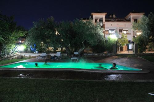 una piscina por la noche con gente en ella en Apartamentos La Suerte, en Hinojares