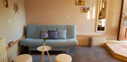 Apartment Borna في بازين: غرفة معيشة مع أريكة زرقاء وطاولة