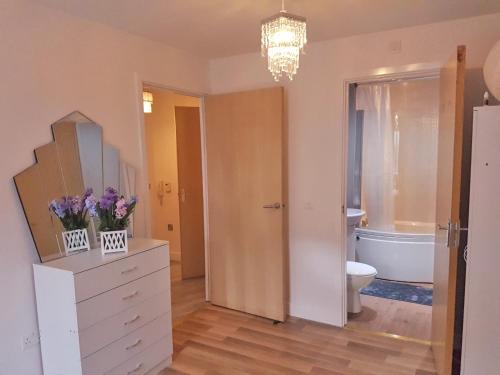 a bathroom with a white dresser and a toilet at 3 Bed Luxury Town Center Apartment with 50 inch 4K TV (Netflix & NowTV Ent. Pass) in Northampton
