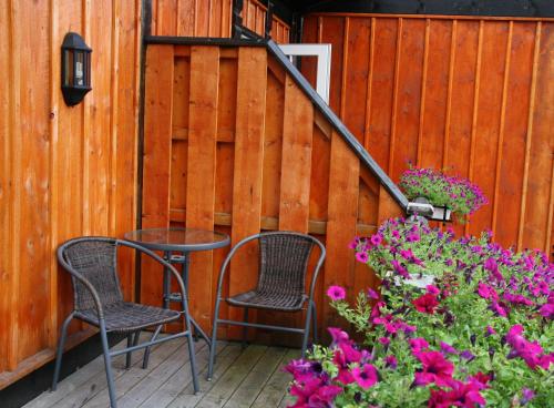 a patio with two chairs and a table and flowers at Sølvgarden Hotel in Rysstad