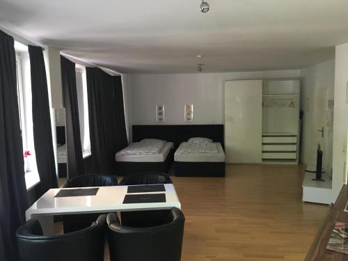 een kamer met 2 bedden, 2 stoelen en een tafel bij Dorya am Ring in Keulen