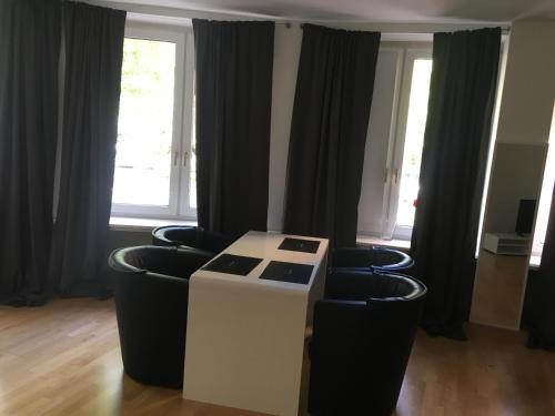 een kamer met 2 stoelen, een tafel en ramen bij Dorya am Ring in Keulen