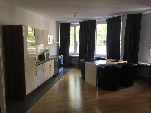a kitchen with white cabinets and a table and chairs at Dorya am Ring in Cologne