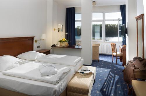 ein Hotelzimmer mit 2 Betten und einem Schreibtisch in der Unterkunft Hotel Deutscher Kaiser in Travemünde