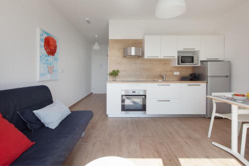 a living room with a couch and a kitchen at Apartments Coast 27 in Podgora