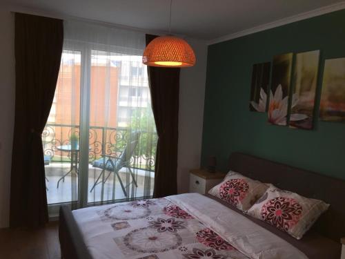 a bedroom with a bed and a window with a balcony at Azur Apartment Deluxe in Chernomorets