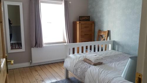 a small bedroom with a crib and a window at Archie's Rest in Drumshanbo