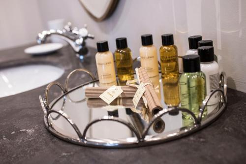 a bathroom counter with a group of bottles of hair products at Holly Lodge Boutique B&B in Thursford