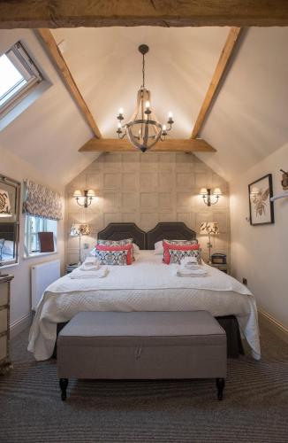 a bedroom with a large bed with a chandelier at Holly Lodge Boutique B&B in Thursford