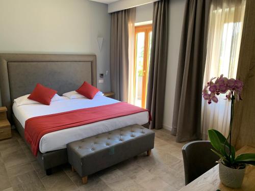 a bedroom with a large bed with red pillows at Hotel Ristorante La Quartina in Mergozzo