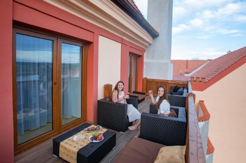 two women sitting on the balcony of a house at Residence Safari Resort - Chateau in Borovany