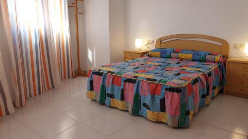ein Schlafzimmer mit einem Bett mit einer bunten Decke darauf in der Unterkunft Apartamento Playa Lo Pagán in Lo Pagán