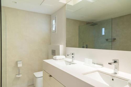 a bathroom with a sink and a toilet and a mirror at Marina Puente Romano - Groundfloor - 3 Bedrooms in Marbella