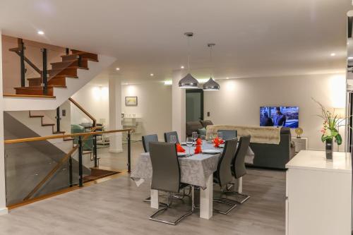 a dining room and living room with a table and chairs at A&M House II Luxury Holidays Home in Arco da Calheta