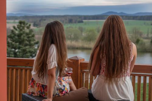 two women sitting on a porch with a glass of wine at Residence Safari Resort - Chateau in Borovany