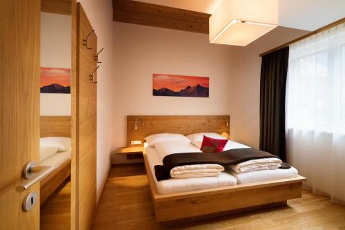 ein kleines Schlafzimmer mit einem Bett und einem Fenster in der Unterkunft AlpinLodges Matrei in Matrei in Osttirol