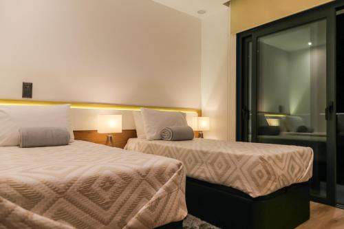 una habitación de hotel con dos camas y una silla en A&M House II Luxury Holidays Home, en Arco da Calheta