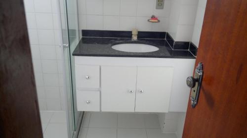 a bathroom with a sink and a glass shower at Dom Yargo II in Arraial do Cabo