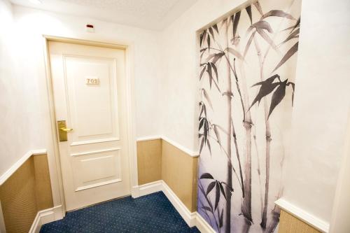 a hallway with a door with a painting on the wall at Hotel Alfonso VIII in Soria