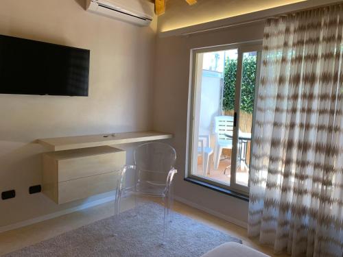 a room with a desk and a television and a window at Suite Cavour - SunTripSicily in Riposto