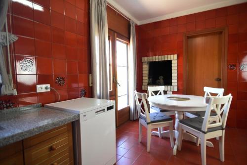 a kitchen with a table and chairs and red tiles at Casa Bel in Sant Carles de la Ràpita