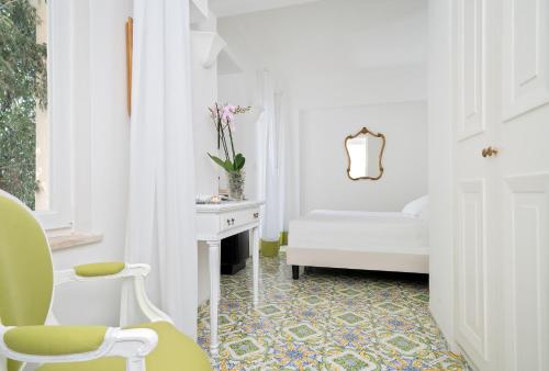 a white room with a chair and a table at Sina Flora in Capri