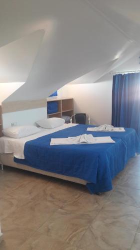 a bedroom with a large bed with blue sheets at Rota Hotel in Dalyan