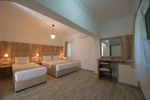 a hotel room with two beds and a desk at Costa Maya Bodrum in Bodrum City