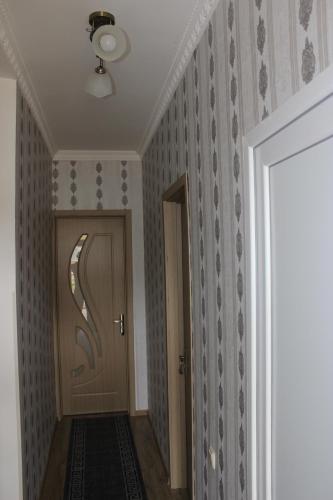 a hallway with a door in a room with wallpaper at Giorgi's Homestay in Kutaisi