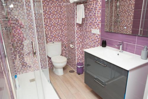 a bathroom with a toilet and a sink and a shower at Hostal Kukia in Noya