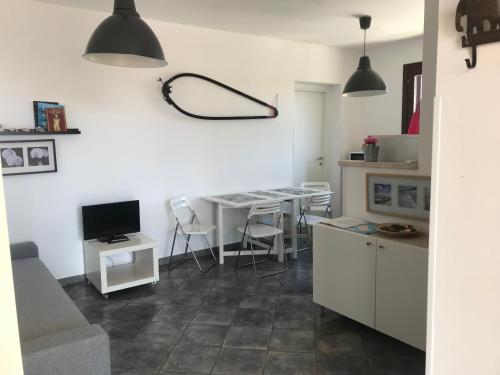 a living room with a kitchen and a table with a television at Le Casuzze del Residence Lido Burrone in Favignana