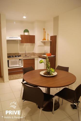 a kitchen with a wooden table and chairs in a room at Boulevard Suíte Hotel by WAM Experience in Caldas Novas