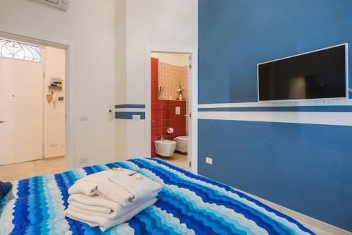 サレルノにあるSara’s SeaView Apartmentの青いベッドルーム(ベッドの上にタオル付)