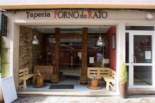 un restaurante con mesas en la parte delantera de un edificio en Hostal Kukia, en Noia