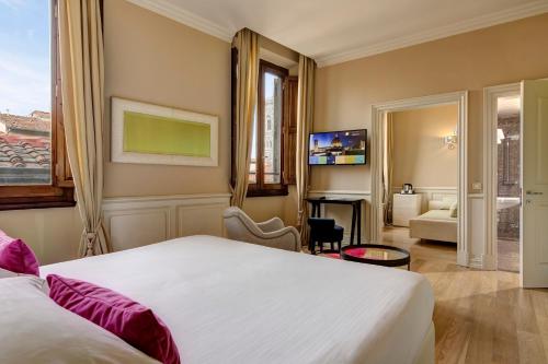 a bedroom with a large bed and a living room at Grand Hotel Cavour in Florence