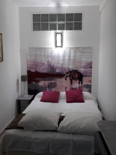 1 dormitorio con 1 cama grande y una pintura en la pared en Leucate,au calme,dans la verdure, dans mas occitan sécurisé en Leucate