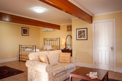 a living room with a couch and a bed at Angaston Saleyards Luxury Accommodation in Angaston