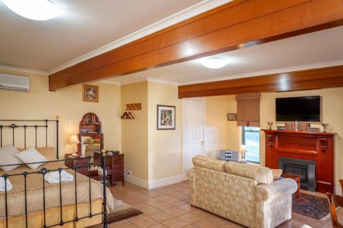 a living room with a bed a couch and a tv at Angaston Saleyards Luxury Accommodation in Angaston