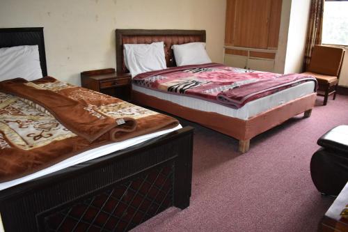 two beds sitting next to each other in a room at Hotel Islamabad Residency in Islamabad