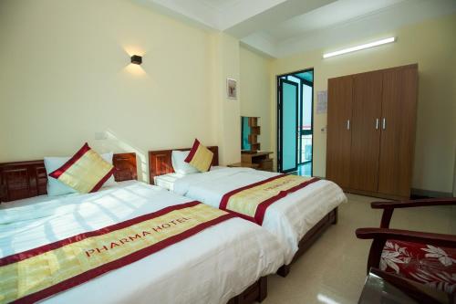 a bedroom with two beds and a door to a balcony at Pharma Hotel in Diện Biên Phủ